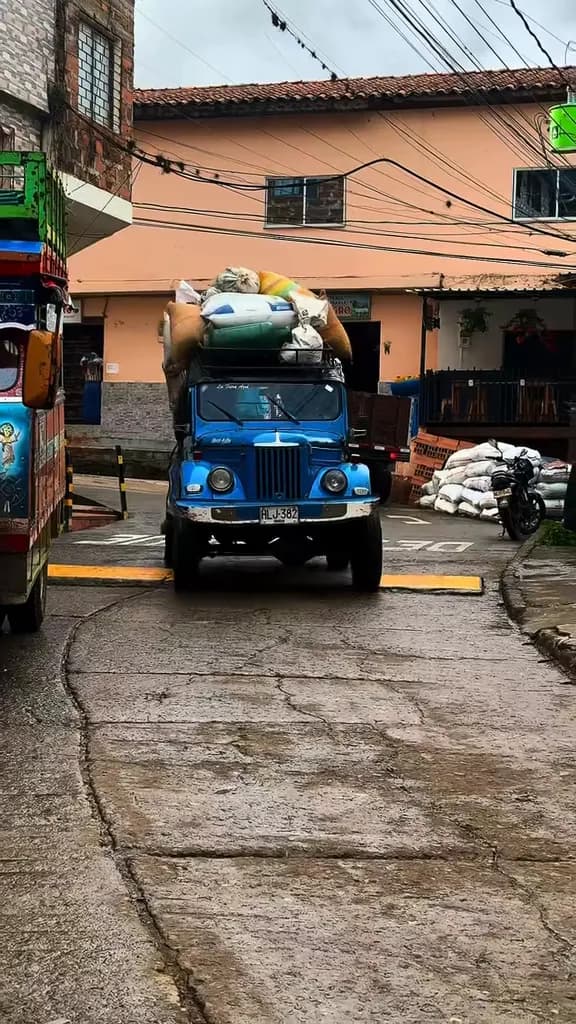 Jeep cargado de bultos de café en una calle de Caicedo